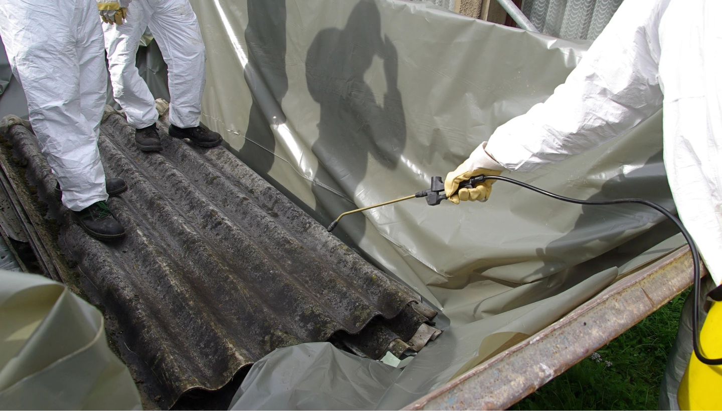 A person spraying paint on the roof of a building.