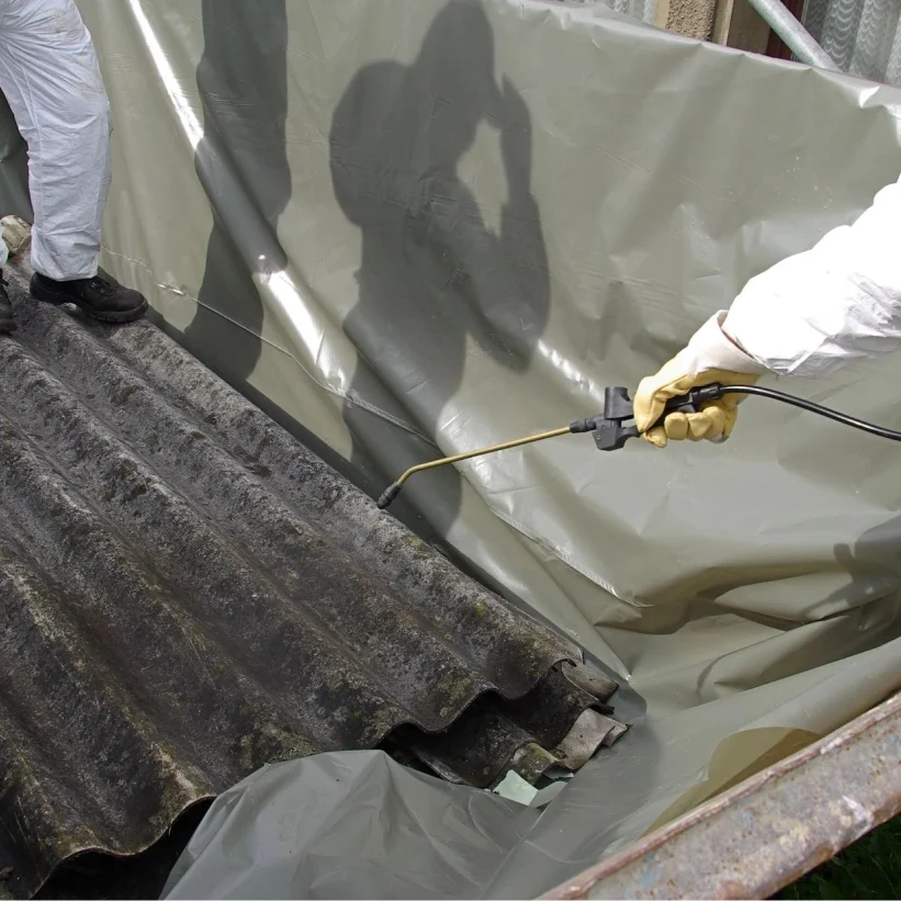 A person spraying paint on the roof of a building.